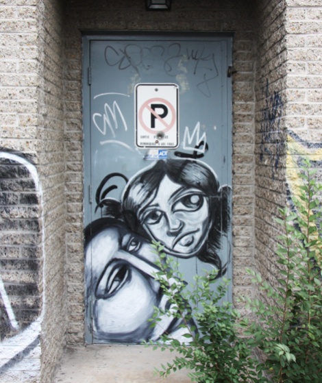 Labrona (bottom) and artist who asked to remain anonymous (top) on door in alley behind St-Denis