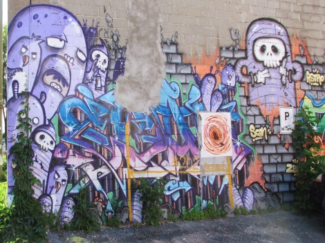 Scaner graffiti within Astro mural. Visible in the middle is a wheatpaste by Graffiti Knight.