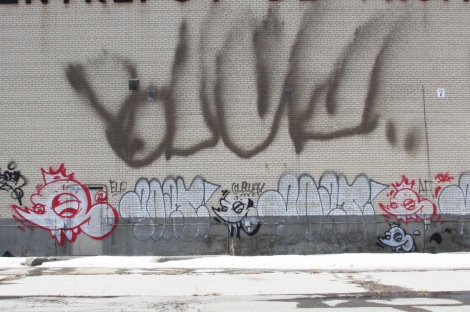 Scaner 'heads' with graffiti by unidentified writer, on abandoned warehouse