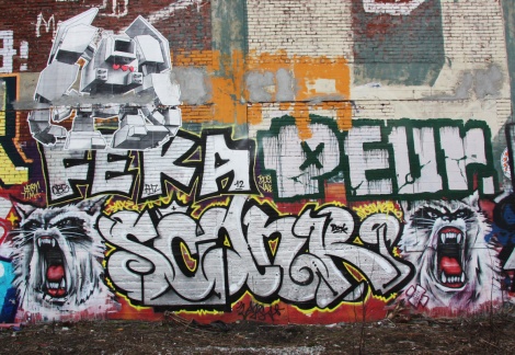 letters by Scaner (bottom) between hissing cats by Axe, Feka and Peur (middle) and wheatpaste by Lovebot (top), by train tracks.