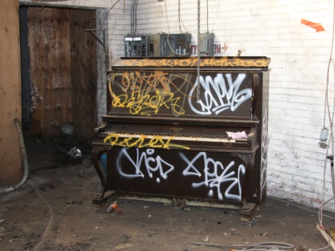 tagged piano in the abandoned Transco; tags include Nock for RCD, Rizek, Resok, Meth.