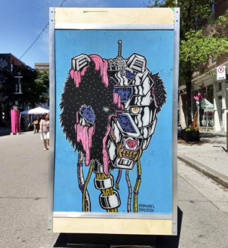 Raphael Dairon on the reverse of an ad/info board for the 2018 edition of Mural Festival
